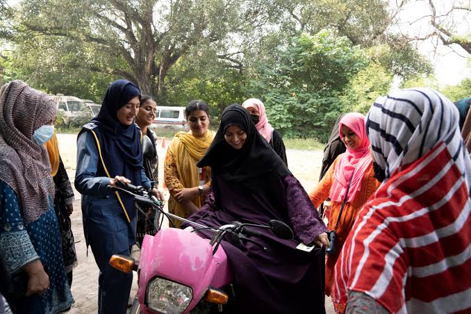 Women learning to ride a motorcycle with a female instructor